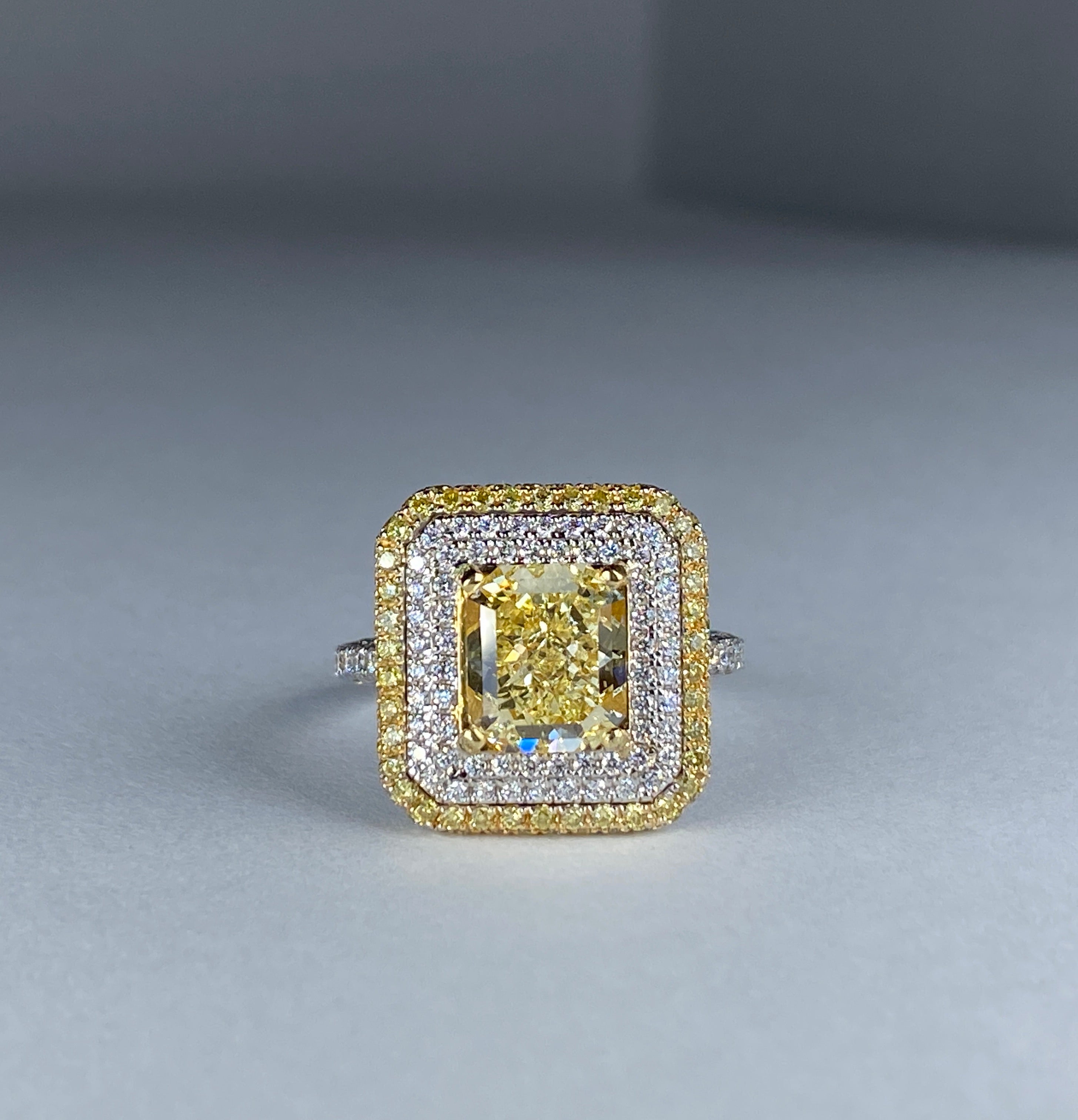 Fancy yellow radiant-cut diamond ring with a double halo