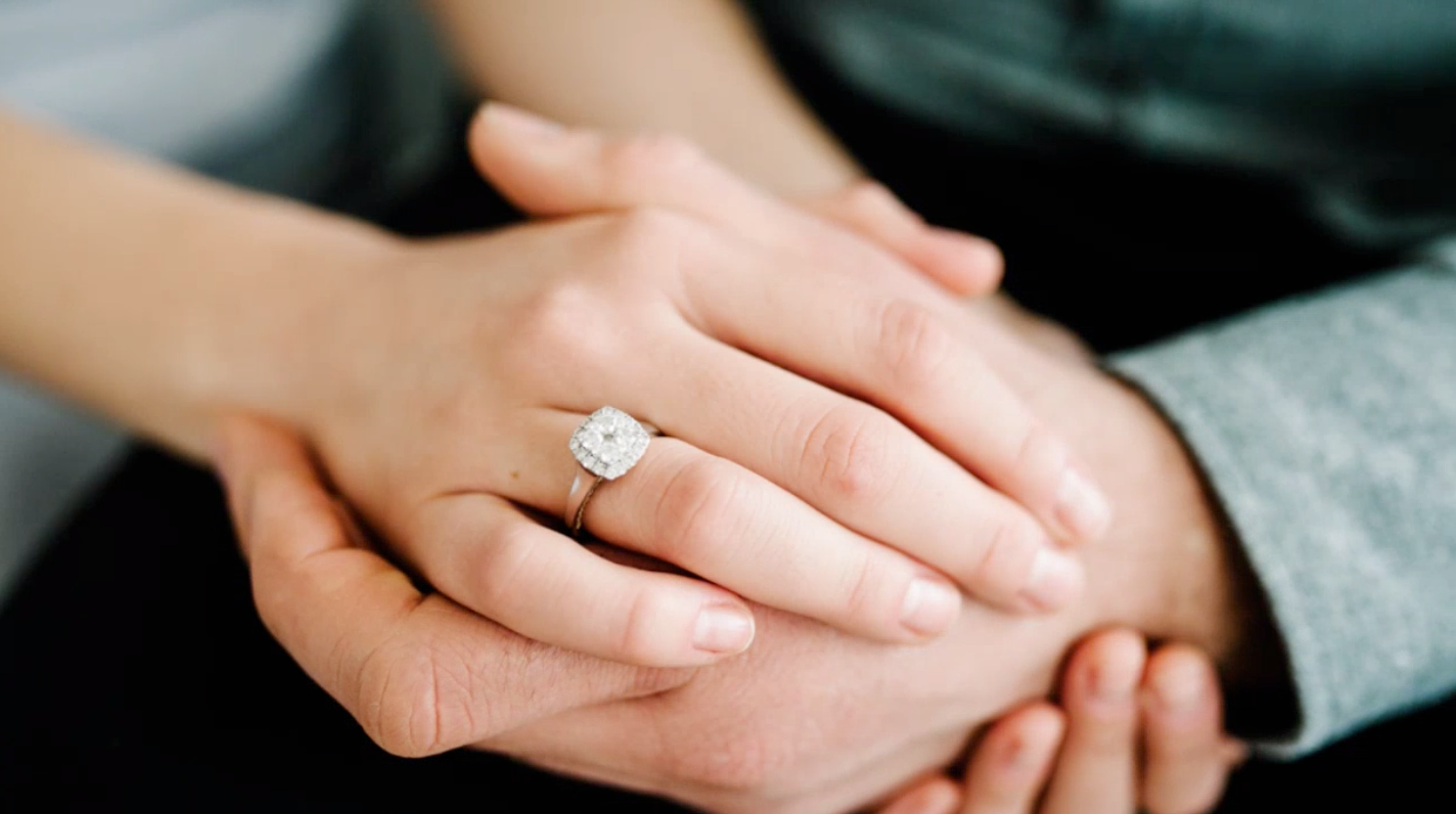 A newly engaged couple holding hands