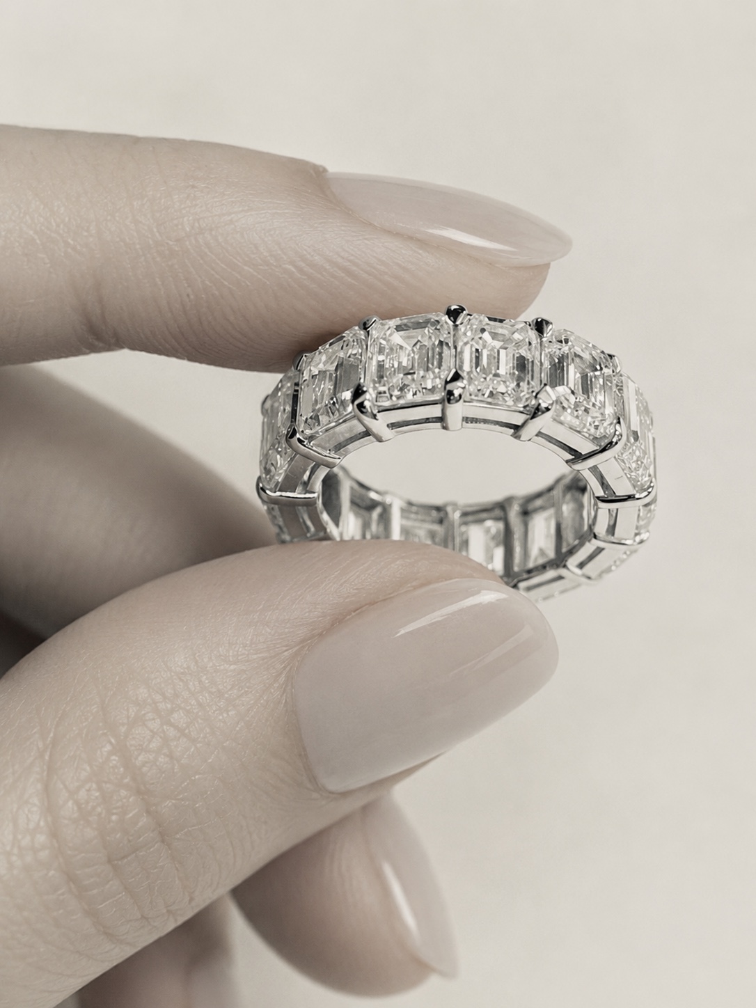 Emerald cut diamond eternity band held by hand